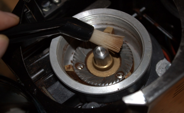 Cleaning a coffee grinder with brush